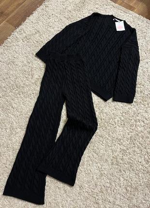 Чорний вʼязаний костюм з косичками светр і штани брюки кльош