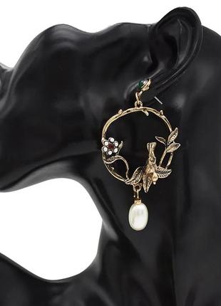 Жіночі сережки заокруглені у формі птиці та квітки декор камені перли колір золотистий1 фото