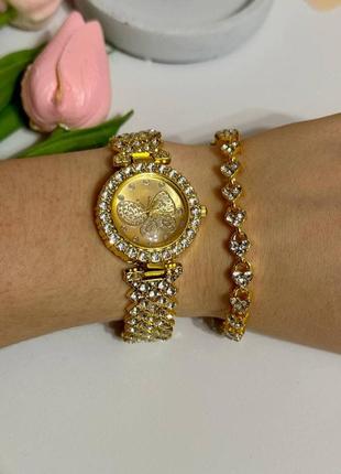 Розкішний годинник жіночий наручний кварцовий цвіт золотистий у каменях декор метелик у комплекті з сяйним10 фото