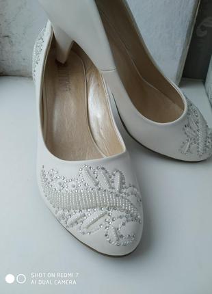 Очень красивые новые белые туфли, украшенные стразами и бисером