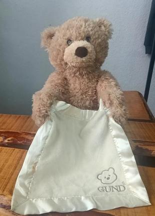 Ведмедик gund baby грає з дитиною в гру , ховаючись за хусткою