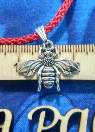 Красная нить с подвеской мушка.