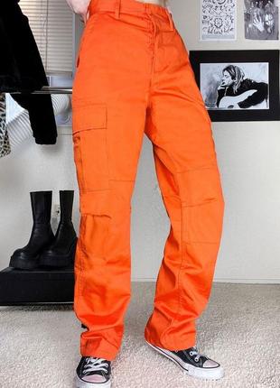 Яскраві помаранчеві штани з боковими накладними кишенями