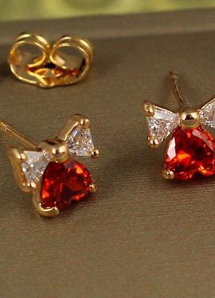 Серьги гвоздики xuping jewelry сердечко с бантиком с красным камнем 7 мм золотистые
