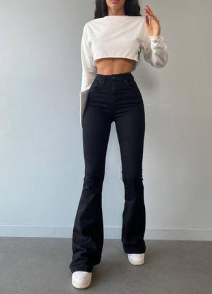 Жіночі вузькі обтислі джинси-кльош із високою талією1 фото