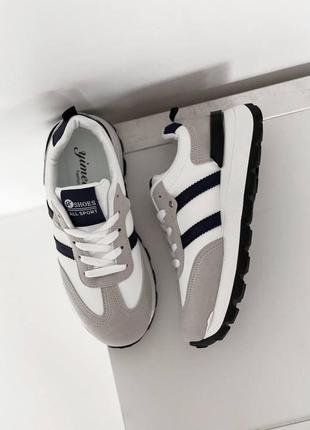 Сіро-білі кросівки, з синіми полосками з еко-шкіри на зубчастій підошві