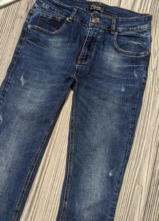 Плотные темно-синие джинсы с потериостями4 фото