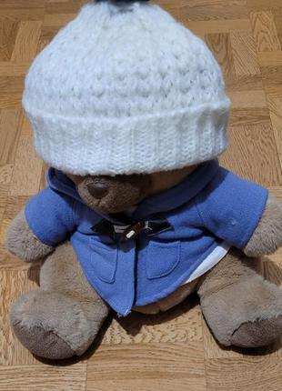 Белая маленька, шапочка бини с синим бубоном.