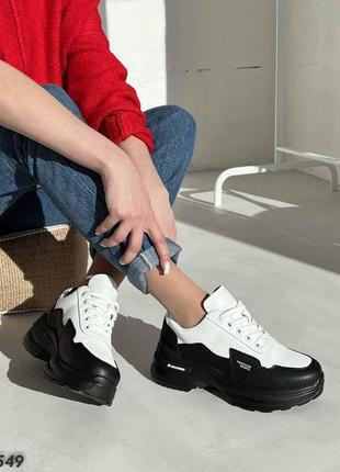 Натуральні шкіряні кросівки білого кольору на масивній чорній підошві