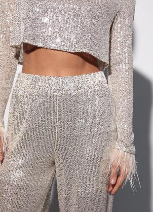Брючный костюм с пайетками и перьями на рукавах
