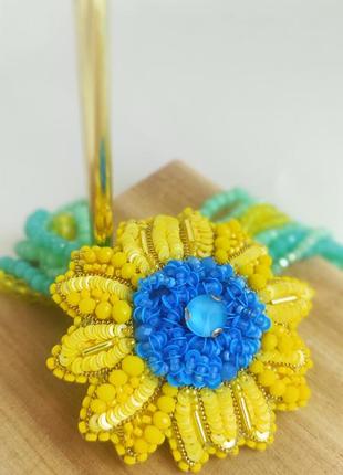 Брошь солнышка в желто голубом цвете.