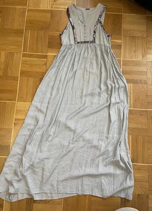 Сукня максі сірого кольору прикрашена  ґудзиками і паєтками .