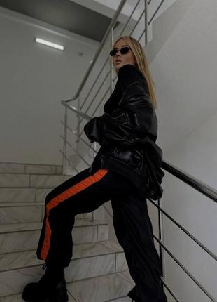 Женские черные ретро стильные трендовые брюки из плащевки с оранжевыми вставками 2024 года.3 фото