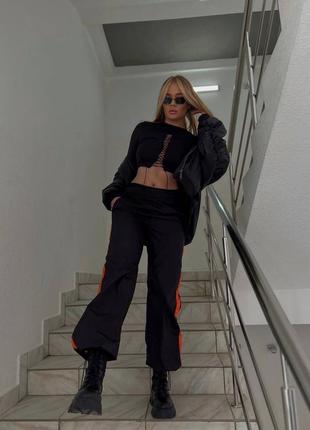 Женские черные ретро стильные трендовые брюки из плащевки с оранжевыми вставками 2024 года.7 фото