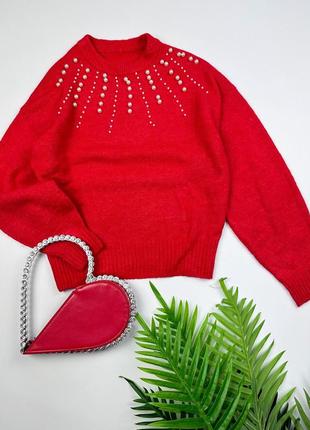 Яскраво-червоний светр із білими перлинами