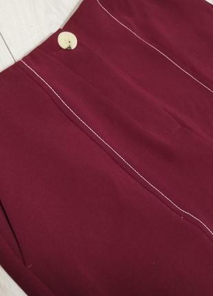 Широкие бордовые брюки с карманами и контрастной окантовкой4 фото