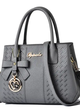 Жіноча стильна шкіряна сумочка модного бренду сумочка з ремінцями брелок2 фото