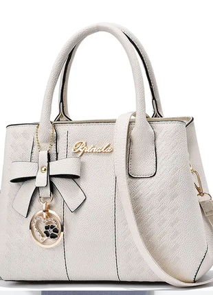 Жіноча стильна шкіряна сумочка модного бренду сумочка з ремінцями брелок5 фото