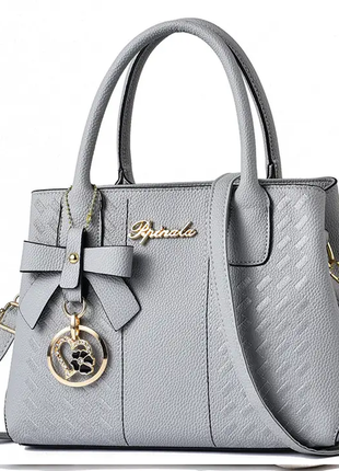 Жіноча стильна шкіряна сумочка модного бренду сумочка з ремінцями брелок7 фото
