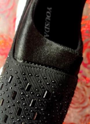 Женские кроссовки с лаковыми вставками украшены стразами в черном цвете.3 фото