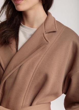 Трикотажний довгий кардиган-пальто бежевого кольору під пояс на запах з кишенями6 фото