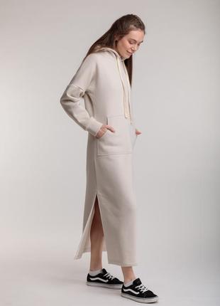 Длинное трикотажное прямое теплое платье бежевого цвета с разрезами, капюшоном и карманом5 фото