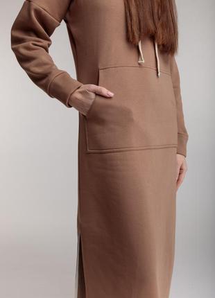 Длинное трикотажное прямое теплое платье бежевого цвета с разрезами, капюшоном и карманом5 фото