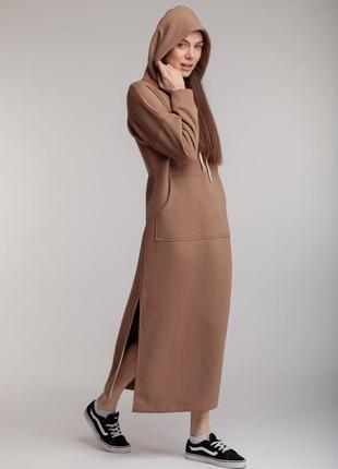 Длинное трикотажное прямое теплое платье бежевого цвета с разрезами, капюшоном и карманом1 фото
