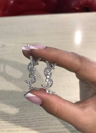 Брендовые серьги серебряного цвета в форме логотипа с камнями