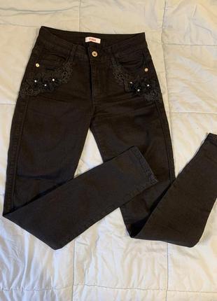 Черные джинсы украшены кружевом