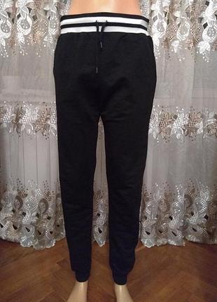 Чорні спортивні штани з білими смугами на поясі