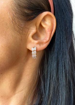 Розкішні сережки з камінцями у позолоті