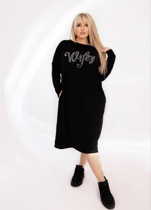 Сукня декорована оксамитовою стрічкою та стильним написом із камінням.