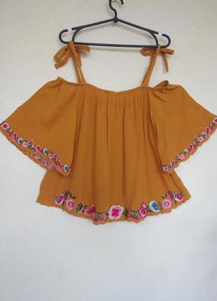 Помаранчева блуза жатка з відкритими плечами по краях вишивка різнокольоровими квітами