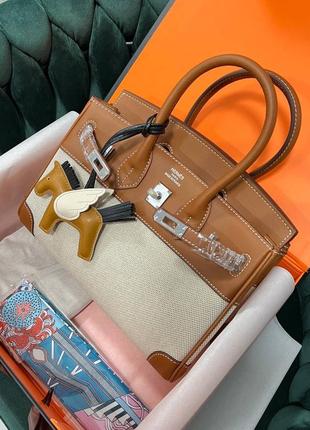 Женская сумка hermes birkin выполнена из текстиля и кожи с серебряной фурнитурой.