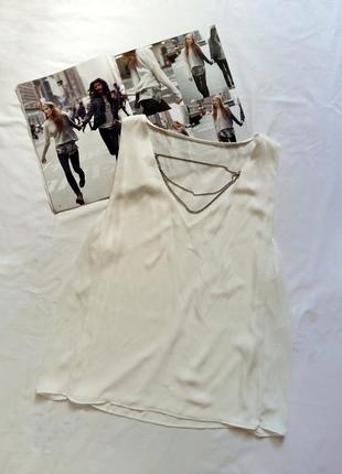 Біла блуза з декором з ланцюжка на декольте