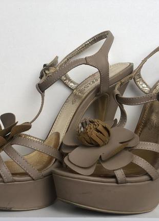 Бежеві босоніжки з квіткою на високому каблуці.