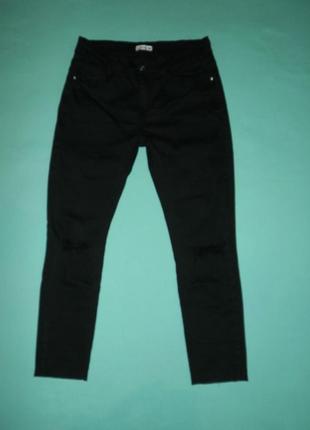 Чорні джинси з дірками на колінах.2 фото