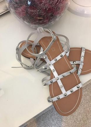 Кожаные гладильные блестящие серебристые босоножки, сандалии с заклепками металлик1 фото