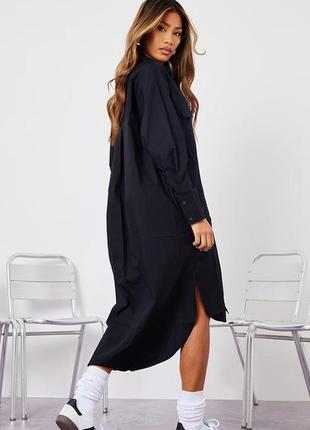 Чорна сукня-сорочка міді з глибокою
кишенею | крапелькою1 фото