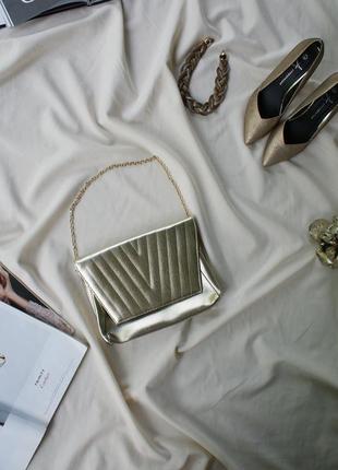 Золотистая сумка клатч в стиле известного модного дома1 фото