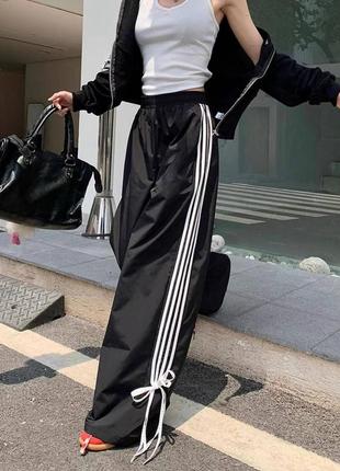 Штани на високій посадці широкі прямі з білими лампасами брюки палаццо спортивні стильні з бантиками чорні3 фото