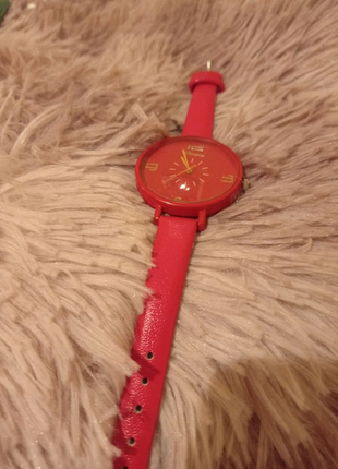 Жіночий наручний годинник червоного кольору.