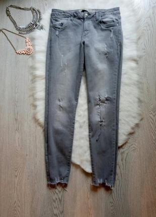 Серые плотные джинсы скинни с необработанным краем потертостями дырками на коленях