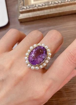 Кольцо золотого цвета в винтажном стиле с фиолетовым камнем.