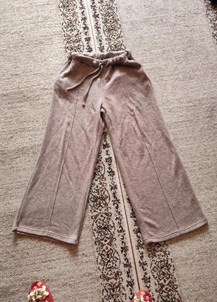 Расклешённые брюки с легким розовым оттенком