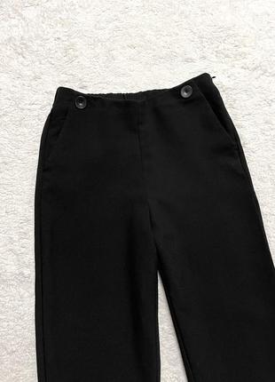 Укороченные однотонные брюки насыщенного черного цвета9 фото