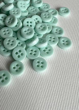 Ґудзик сорочковий біла бокова полоска світлий 4отв зелений 10мм пластик