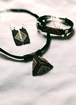 Комплект прикрас. кольє з підвіскою, браслет та сережки з бісеру на шкіряній основі.