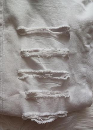 Белые скошенные стрейчевые зауженные порезанные белые джинсы в утяжеление4 фото